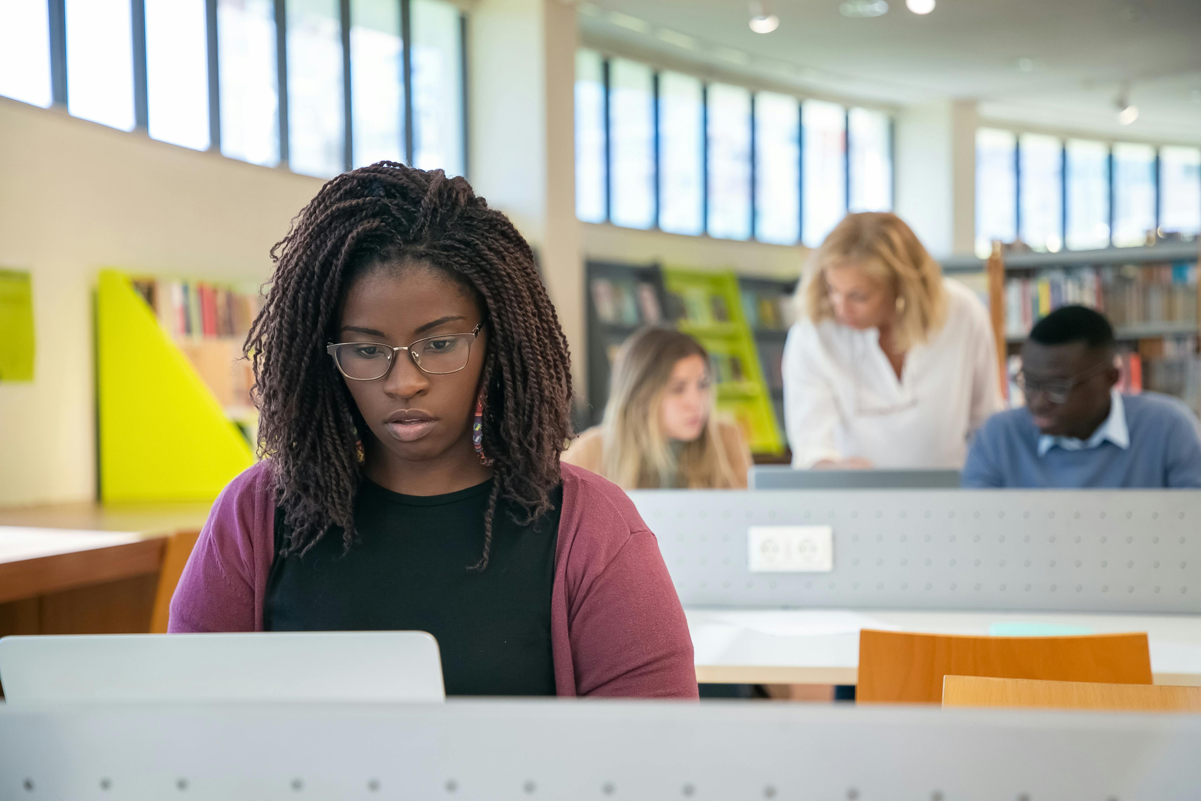 Student working on laptop in modern library setting